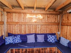 A snug with seating and a neon sign at Honeymug in Branton near Powburn