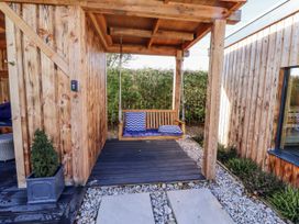 An outdoor area with a swing seat and wooden structure at Honeymug in Branton near Powburn
