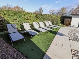 A garden with loungers and a table at Honeymug in Branton near Powburn