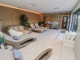 A spa with lounge chairs and a glass door at Honeymug in Branton near Powburn