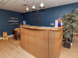 A reception area with a wooden desk and shelves at Honeymug in Branton near Powburn
