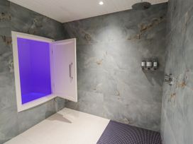 A bathroom with a shower and soap dispensers at Honeymug in Branton near Powburn