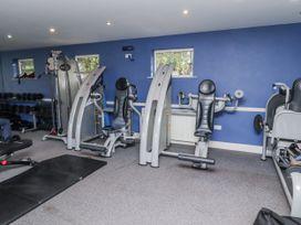 A gym with exercise machines and dumbbells at Honeymug in Branton near Powburn