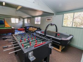 A game room with a foosball table and air hockey table at Honeymug in Branton near Powburn