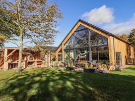 A house with large windows and outdoor seating at Honeymug in Branton near Powburn