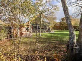 A garden area with grass and trees at Honeymug in Branton near Powburn