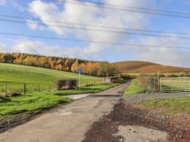 A road with a signpost and a gate at Honeymug in Branton near Powburn