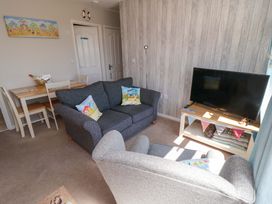 A living room with a sofa and television at Beach House 