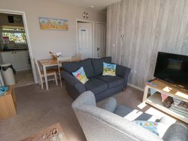A living room with furniture and a television at Beach House