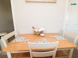 A dining table with a wine bottle and placemats at Beach House
