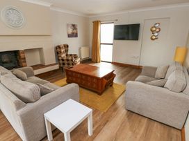 A living room with a sofa and armchair at Tig Bhan in Narberth