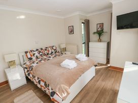 A bedroom with a bed and dresser at Tig Bhan in Narberth