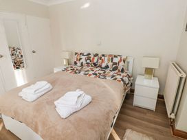 A bedroom with a bed and nightstands at Tig Bhan in Narberth