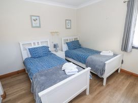 A bedroom with twin beds and nightstand at Tig Bhan in Narberth