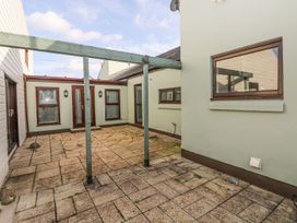 An outdoor area with a patio and surrounding walls at Tig Bhan in Narberth