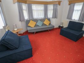 A living room with seating and a lamp at Static Caravan in 