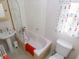 A bathroom with a bathtub, sink, and toilet in a Static Caravan