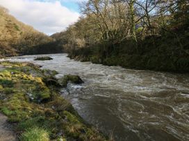 A river with flowing water and rocks beside it in a natural setting