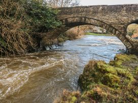 A bridge over a river with trees and grass at Static Caravan