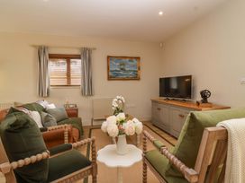 A living room with a tv and sofa at The Annex in Burford