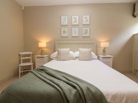 A bedroom with a bed, nightstands, and wall art at The Annex in Burford