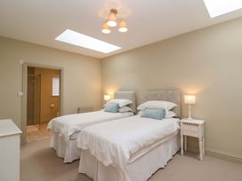 A bedroom with twin beds and a nightstand at The Annex in Burford