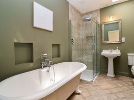 A bathroom with a bathtub, shower, sink, and toilet at The Annex in Burford