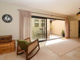 A room with a rocking chair and sliding doors to an outdoor area at The Annex in Burford