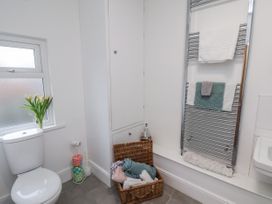 A bathroom with a toilet, towel rack and basket at 1 Castle Terrace in Thirsk