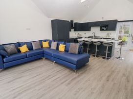 A living room with a sofa and kitchen area at Cottage 1 in Laugharne