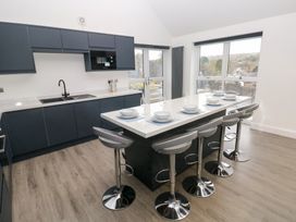 A kitchen with bar stools and countertop at Cottage 1 in Laugharne