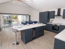 A kitchen with a kitchen island and bar stool at Cottage 1 in Laugharne