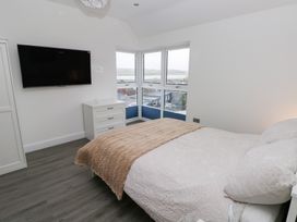 A bedroom with a bed and television at Cottage 1 in Laugharne