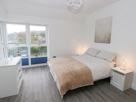 A bedroom with a bed and nightstand at Cottage 1 in Laugharne