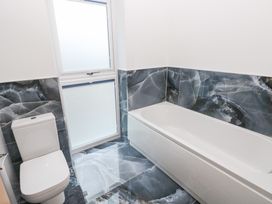 A bathroom with a bathtub and toilet at Cottage 1 in Laugharne