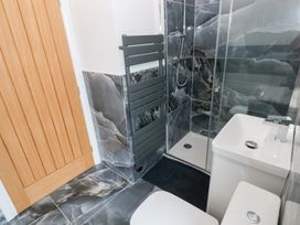 A bathroom with shower, toilet, and towel radiator at Cottage 1 in Laugharne