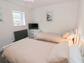 A bedroom with two beds and a television at Cottage 1 in Laugharne