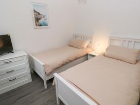 A bedroom with two single beds and a television at Cottage 1 in Laugharne