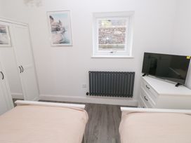 A bedroom with two beds and a television at Cottage 1 in Laugharne