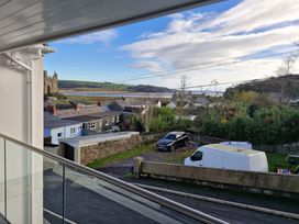 A view of houses and cars with a castle in the background at Milkwood Villa Laugharne