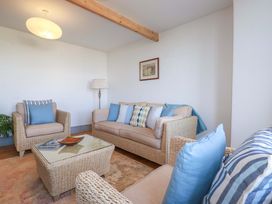 A living room with a sofa and armchairs at Tradewinds in Newquay