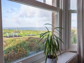 A view from a window showing a plant and playground equipment at Tradewinds in Newquay
