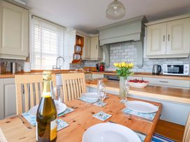 A kitchen with a dining table and chairs at Tradewinds in Newquay