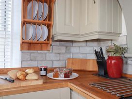 A kitchen with plates, bread, and utensils at Tradewinds in Newquay