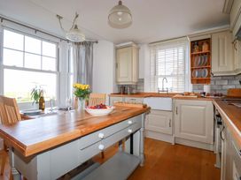 A kitchen with a table and chairs at Tradewinds in Newquay
