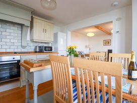 A kitchen with a dining table and chairs at Tradewinds in Newquay