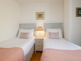 A bedroom with two single beds and a lamp at Tradewinds in Newquay