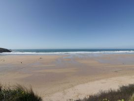 A beach with sand and ocean waves at Tradewinds in Newquay