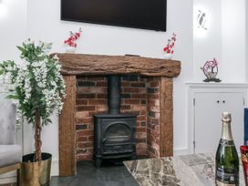 A fireplace with a stove and wooden mantel in a living room at Aspen Boutique