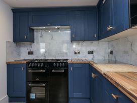 A kitchen with blue cabinets and a black gas stove at Aspen Boutique